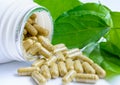 Herbal medicine capsules spilling out of a bottle Royalty Free Stock Photo