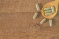 Herbal Medicine capsules in wooden spoon on wooden table. Royalty Free Stock Photo