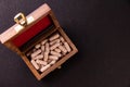 Herbal medicine concept. Top view of an ayurvedic capsules filled wooden box on black background with copy space Royalty Free Stock Photo