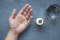 herbal medicine on hand and water glass on table , Royalty Free Stock Photo