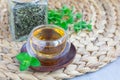 Herbal mint tea in oriental glass cup with fresh peppermint and tea scoop on background, horizontal, copy space Royalty Free Stock Photo