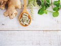 Herbal pills on wooden spoon and green herb. Royalty Free Stock Photo