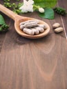Herbal pills in wooden spoon and herbs Royalty Free Stock Photo