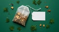 Herbal tea bag with dried citrus and blank label on green background Royalty Free Stock Photo
