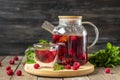 Herbal tea with berries, raspberries, mint leaves and hibiscus flowers in glass teapot and cup on wooden table Medicine for cold Royalty Free Stock Photo