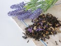 Herbal tea with blue dried flowers is scattered on the table with lavender flowers on a linen napkin