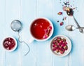 Herbal tea, dry roses and jam on blue colored table