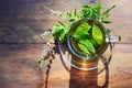 Herbal tea from fresh peppermint leaves and flowers in a glass cup on a rustic wooden table, high angle view from above, copy Royalty Free Stock Photo