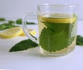 Herbal tea in a glass cup , fresh lemon balm leaves. The tea balm, the essential oil, and the extract are used in Royalty Free Stock Photo