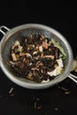 Herbal Acaccia Tea Healthy Drink in bowl and sieve over Black Background copy space. Healthy Drink, coldness.