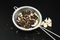 Herbal Acaccia Tea Healthy Drink in bowl and sieve over Black Background copy space. Healthy Drink, coldness.