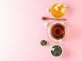 Herbal tea, honey, Jasmine flowers and a wooden spoon on a pink table. The composition of the morning Breakfast. Flat lay.