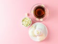 Herbal tea, honey, Jasmine flowers and a wooden spoon on a pink beautiful table. The composition of the morning Breakfast. Flat la