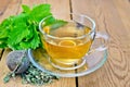 Herbal tea with melissa in a cup and strainer Royalty Free Stock Photo