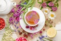 Herbal tea with rosehip, chamomile and lemon in a white cup on a white wooden table with flowers Royalty Free Stock Photo