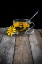 Herbal tea with yellow daisy on wooden table Royalty Free Stock Photo