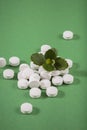Herbal and Vitamin white pills healthy food freely laid on green background