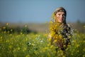 The herbalist stands in a cultivated field of rapeseed and looks up smiling. Royalty Free Stock Photo