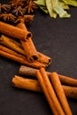 Herbs in kitchen, frame of spices, cinnamon sticks, star anise, wooden spoon, Various spices on stone black table Royalty Free Stock Photo