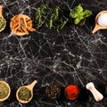 Herbs and spices on black marble background. Ingredients for cooking. Food background