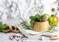 Herbs and Spices, Mortar and Pestle, wooden board, rosemary and basil, oil and pepper and salt on wooden spoon Royalty Free Stock Photo