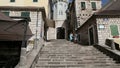 Herceg Novi, Montenegro - 31 June, 2017. Pair of girls tourists climb by stairs to Topla tower with clock of old city