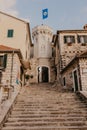 HERCEG NOVI, MONTENEGRO - November 30, 2018: the old town gate with the small clocktower surrounded by old houses, cafes and bars