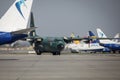 Hercules military cargo plane of the Romanian Air Force on Henri Coanda International Airport between commercial airplanes