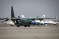 Hercules military cargo plane of the Romanian Air Force on Henri Coanda International Airport between commercial airplanes Royalty Free Stock Photo