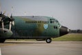 Hercules military cargo plane of the Romanian Air Force on Henri Coanda International Airport between commercial airplanes Royalty Free Stock Photo