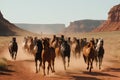 a herd of galloping horses in the desert, surrounded by red rocks Royalty Free Stock Photo