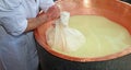 Herdsman Cheesemaker collects cheese from the copper cauldron w Royalty Free Stock Photo