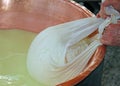 herdsman Cheesemaker collects cheese from the copper cauldron w Royalty Free Stock Photo