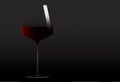 Here is a contemporary wine glass containing red wine on a dark grey background