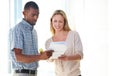 Here are the documents you wanted. two business colleagues discussing paperwork in the office. Royalty Free Stock Photo