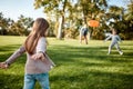 Here we go again. Little girl playing frisbee with her family in the park on a sunny day Royalty Free Stock Photo