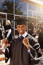 Here I come life. Portrait of a smiling university student holding his diploma outside on graduation day. Royalty Free Stock Photo