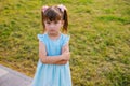 Here is a little girl standing in a public park. The child is offended and upset Royalty Free Stock Photo