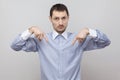 Here and right know. Portrait of serious handsome bristle businessman in classic blue shirt standing and looking at camera and