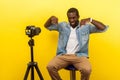 Here and right now, online business training. Portrait of happy friendly man smiling at his professional dslr camera. indoor Royalty Free Stock Photo