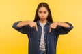 Here and right now! Portrait of girl in denim shirt pointing fingers down, ordering and controlling, demanding result Royalty Free Stock Photo