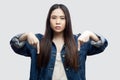 Here and right now. Portrait of serious bossy beautiful brunette asian young woman in casual blue denim jacket with makeup