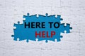 Here to help symbol. Concept words Here to help on white puzzle. Beautiful blue background. Business and Here to help concept.