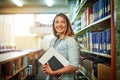 Here to make a success of my studies. Portrait of a university student standing in the library at campus.