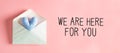 We are Here for You message with a heart cushion in an envelope Royalty Free Stock Photo