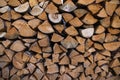 Firewood piles from a farm, in front of the house wall.