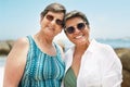 Heres to ageing gracefully with my best friend. two mature friends standing together during a day out on the beach. Royalty Free Stock Photo