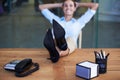 Heres to a job well done. A businesswoman sitting back with her feet on her desk.