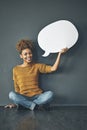 Heres what I have to say. Studio portrait of a young woman holding a speech bubble against a grey background.