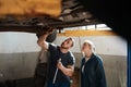 Heres where the problem lies. two mechanics working together under a lifted car. Royalty Free Stock Photo